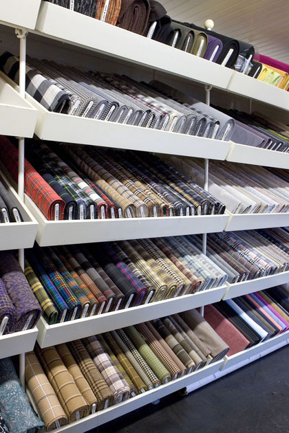 Wand met rollen modestof in de winkel